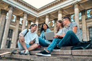 Grupo de estudiantes conversa mientras camina cerca de un campus universitario, escena vinculada con la Tecnicatura en Recursos Humanos a distancia.