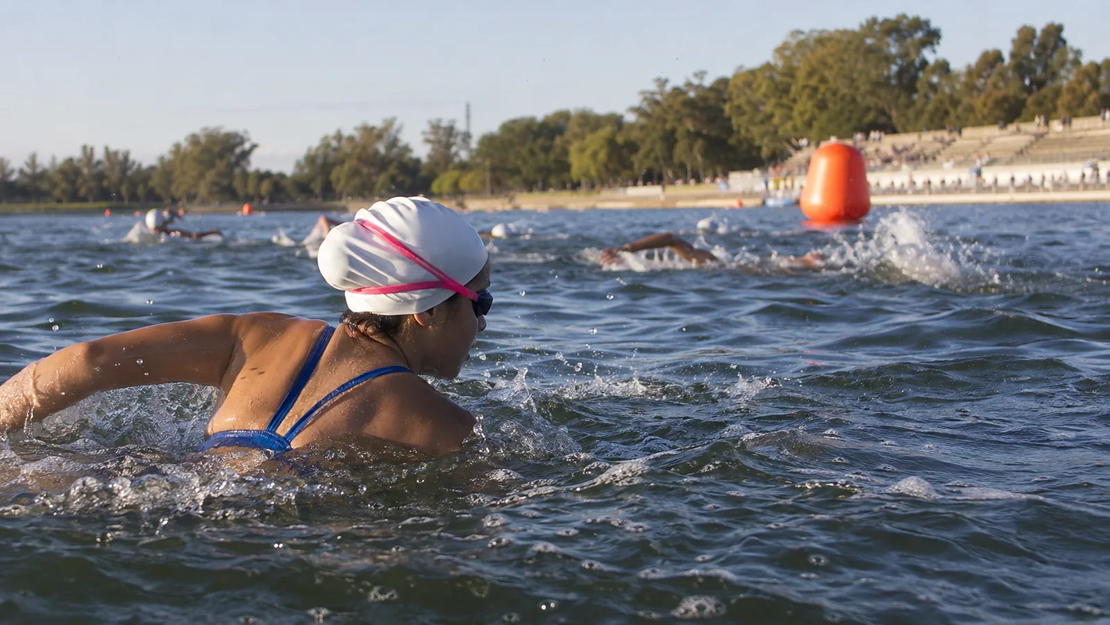 Nadadora juvenil participa en una competencia de aguas abiertas en un lago de Santa Fe.